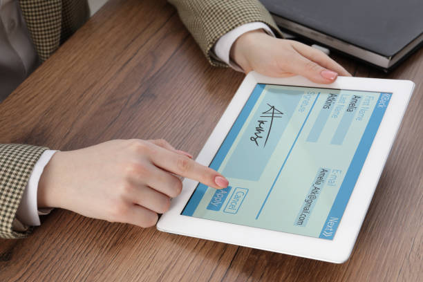 istock Electronic signature. Woman using tablet at wooden table, closeup 1678754022
