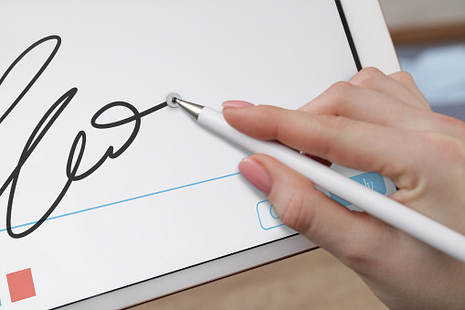 Electronic signature. Woman using stylus and tablet, closeup