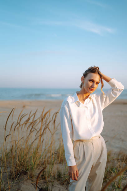 istock Stylish woman posing on autumn beach in wild grass. 1678759558