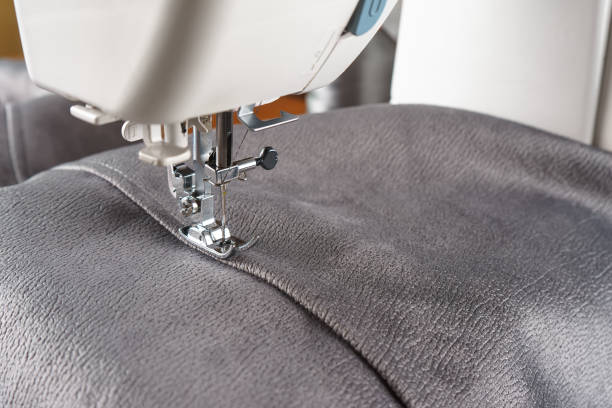 istock Modern sewing machine with gray velours fabric close up 1678761290