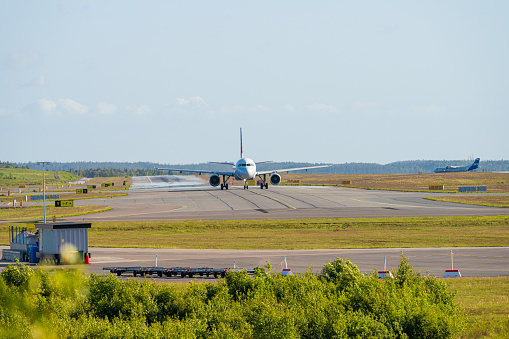 A passenger jet taxis towards an airport gate after landing.