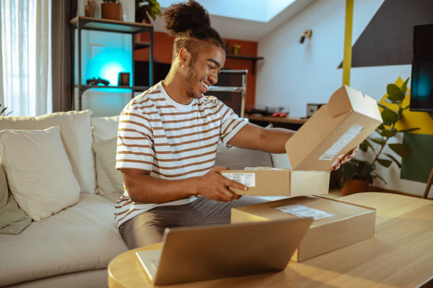 Male customer unpacking the package he ordered online. Online shopping