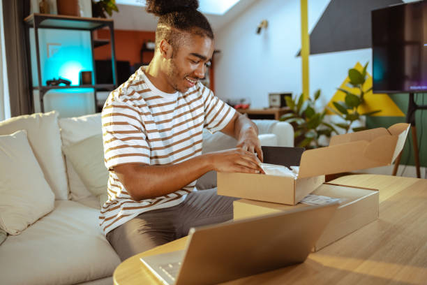 istock Young male customer unpacking cardboard box with online order at home 1678793437