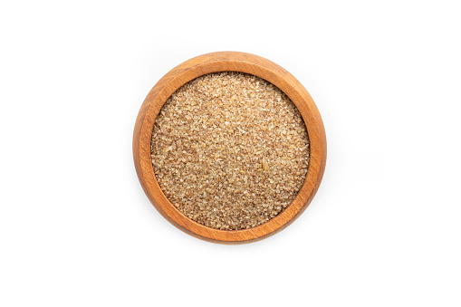 Wooden Bowl Full of Dry raw bulgur isolated on white background.