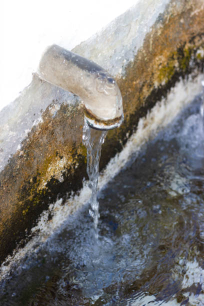 water spout in an old drinking water source in a mountain village. - well fountain water pipe pipe imagens e fotografias de stock