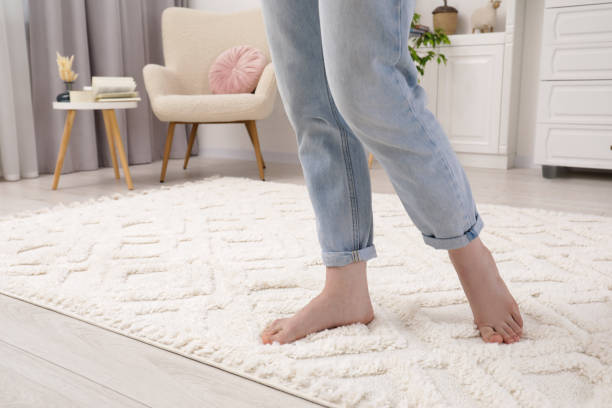 istock Woman standing on beige carpet in room, closeup. Space for text 1678838325