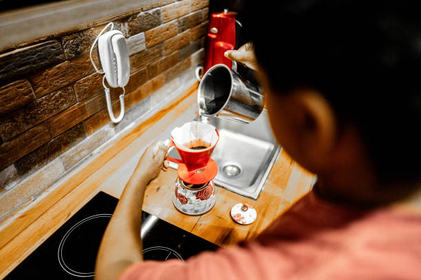 Woman preparing coffee in the kitchen at home