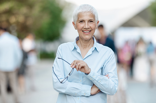 Portrait of a lovely senior businesswoman with short gray hair, looking at the camera