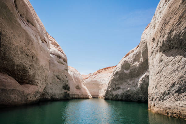 Antelope Canyon from Lake Powell captures the mesmerizing beauty where water meets stone. Towering sandstone cliffs frame the tranquil waters of Lake Powell, leading the eye towards the iconic slot canyons of Antelope Canyon. The play of light and shadow creates a breathtaking scene, showcasing nature's masterpiece of erosion and geological wonder