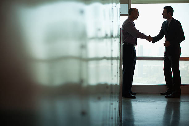 uomini d'affari stringe la mano in ufficio - middle eastern ethnicity business greeting handshake foto e immagini stock