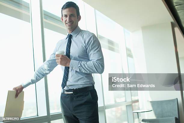 Hombre De Negocios De Pie En La Ventana En Oficina Foto de stock y más banco de imágenes de 30-34 años - 30-34 años, 30-39 años, Adulto