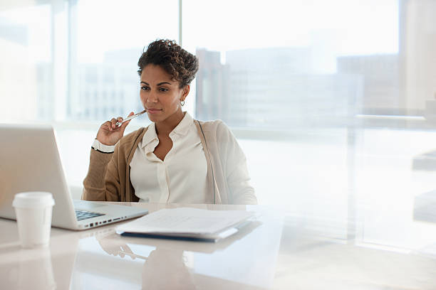 Businesswoman using laptop in office  businesswoman stock pictures, royalty-free photos & images