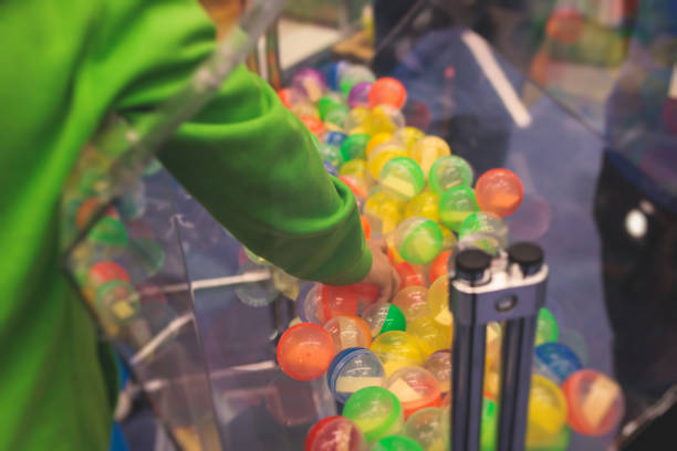 Process of prize drawings, extracting a winning numbers of lottery machine, raffle drum with a bingo balls, bingo machine and winning tickets on event with a host, hands on lottery machine