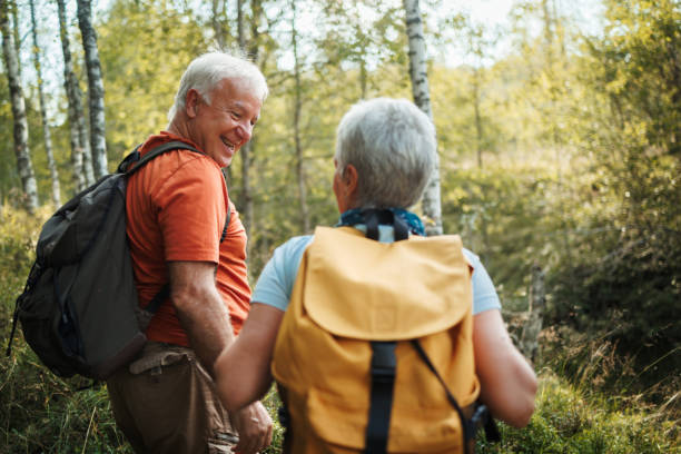 istock Senior hikers bonding while hiking together in forest on sunny day 1678932860