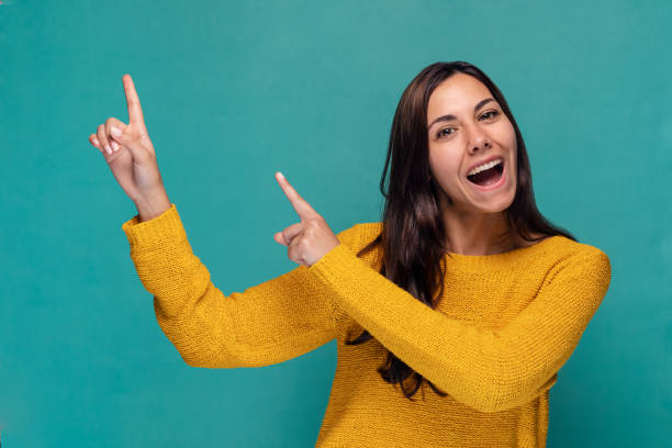 istock Beautiful surprised woman pointing up over blue background 1678932962