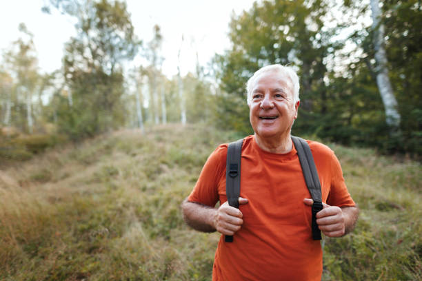 istock Senior man hiking in forest on sunny day 1678933737
