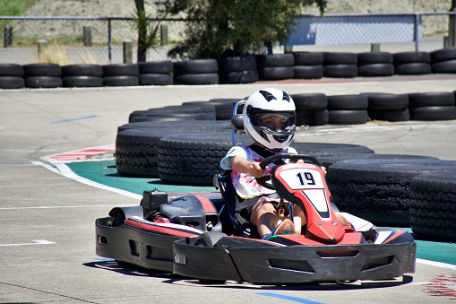 Children driving go-carts on a sports track.