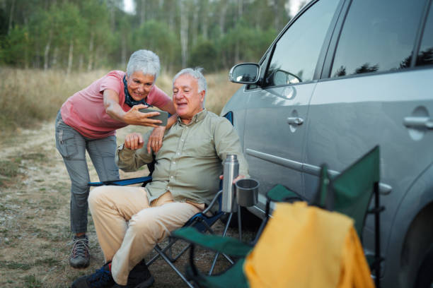 istock Smiling senior couple taking selfie while camping in nature 1678940462