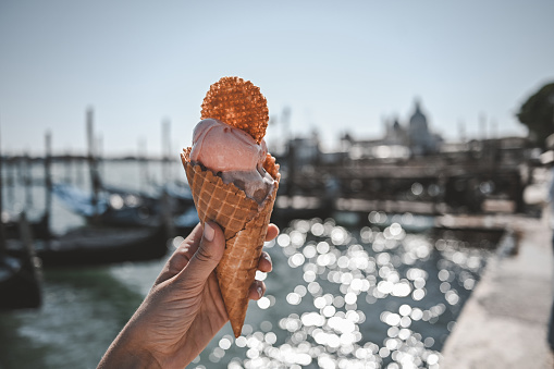 close up of Italian gelato with view of grand canal in Venice.