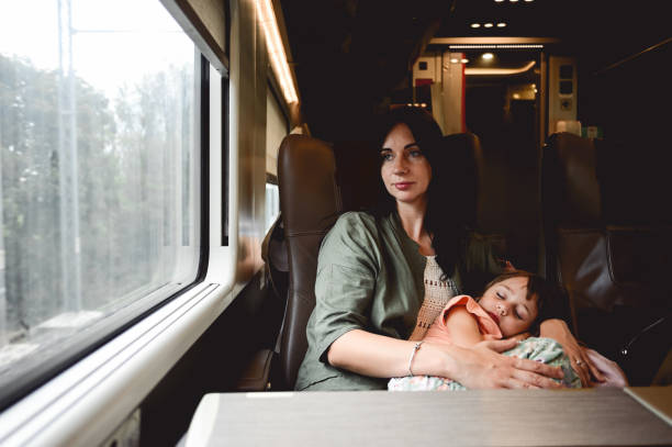 istock Tired mother with sleeping daughter in a train. 1678950393