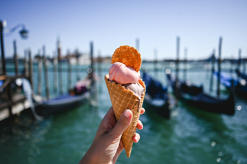 Italian gelato in waffle cone in front of San Marco canal in Venice.