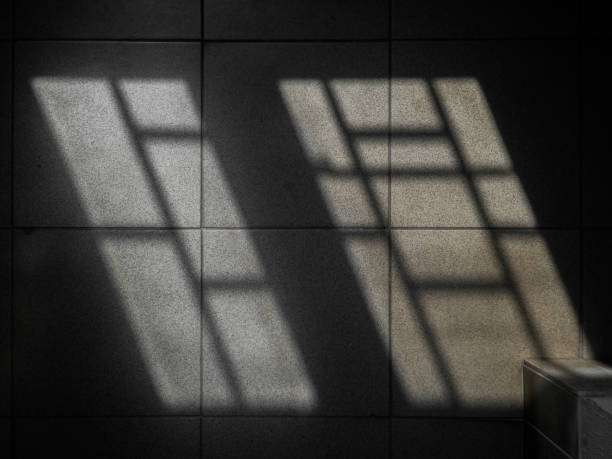 istock Shadow from barred windows on the floor in a dark room. 1678951518