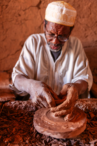 Moroccan potter working in the workshop on the pottery wheel near Ouarzazate, Morocco.