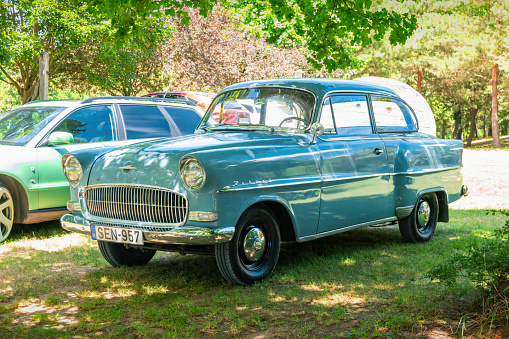An Opel Rekord P1 (from 1950s) is parked in parking spot near Tapolca, Hungary on a sunny day