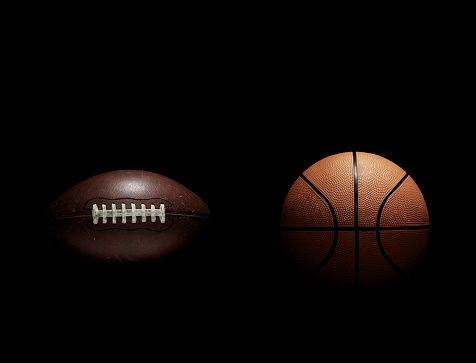 Various sports concept with stack of different balls on black isolated background. Front view.