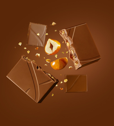 Chocolate pieces with nuts and caramel flying on air