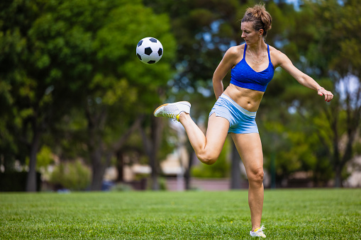 Two female soccer players with soccer ball playing on soccer field. Penalty shot.