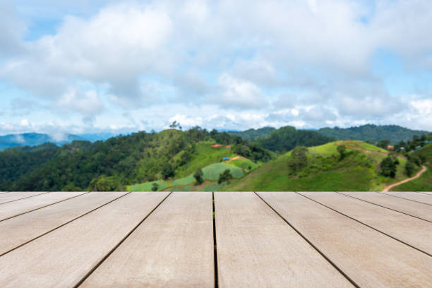Empty old wooden table in front of blurred mountain and clear blue sky background. Can be used for display or montage for show your products.