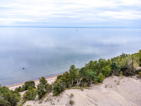 Aerial view of sand dunes in Tadoussac, Quebec, Canada, with the St. Lawrence river during summer day.