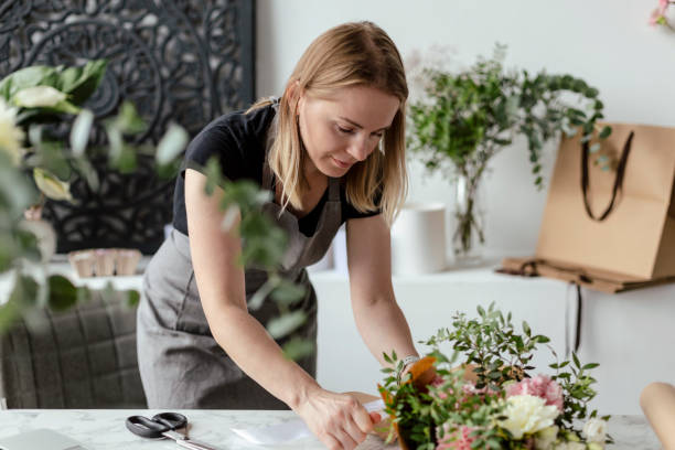 istock Female florist working with flowers 1679128832