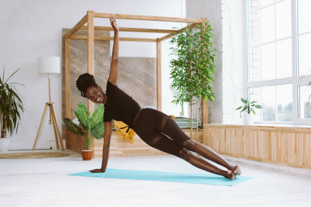 istock Laughing, smiling multicultural woman do yoga exercises on mat. Practicing Vasisthasana side plank with one arm indoors 1679129159