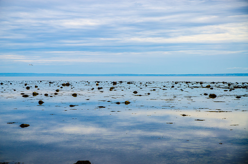 Reflection of sky on St. Lawrence river at low tide during summer evening