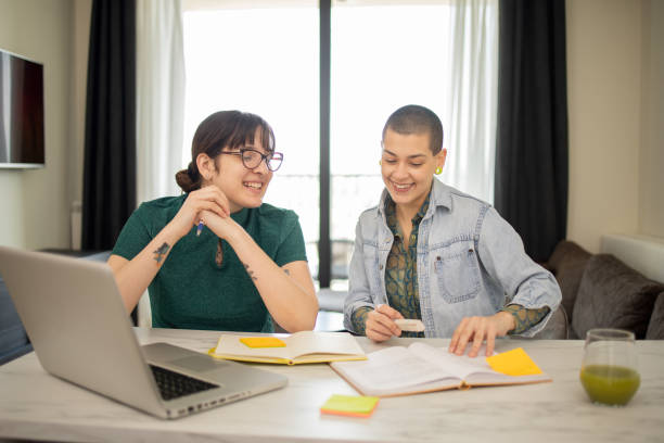 istock Two happy friends are learning together online 1679204072