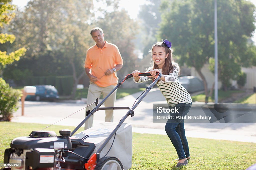 Father and daughter mowing lawn together  Mowing Stock Photo