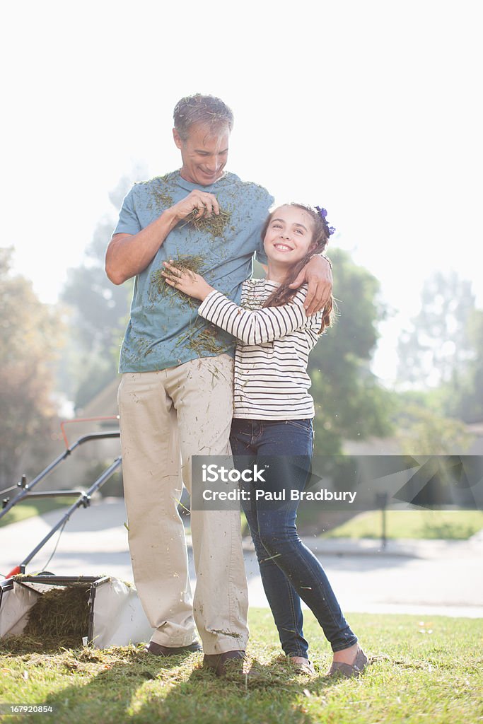 Father and daughter mowing lawn together  50-54 Years Stock Photo