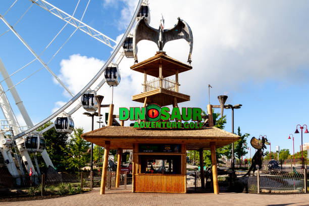 la entrada a dinosaur adventure golf con skywheel de fondo en las cataratas del niágara, canadá. - putting down fotografías e imágenes de stock