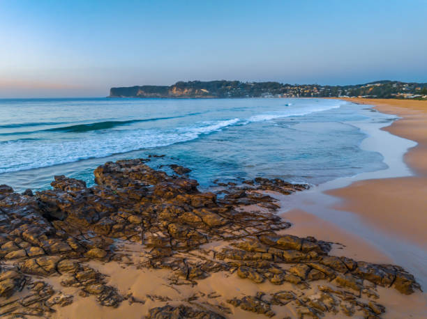 istock Sunrise over the ocean and rock platform with clear skies 1679266142