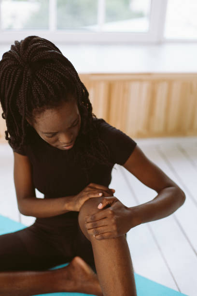 istock Vertical interracial African woman with dreadlocks stretch, yoga in exercise class. Knee ache, athletic injury 1679269787