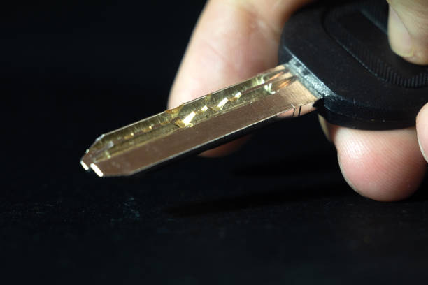 istock Selective blur on the dimple pin key held by blurred fingers isolated on a black background. A dimple pin lock and key is a type of safety key and lock used in locksmith environment. 1679285224