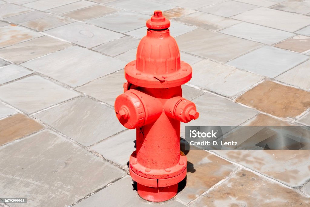 Red Fire Hydrant A bright red fire hydrant on a slate stone tile walkway on a sunny say. Fire - Natural Phenomenon Stock Photo