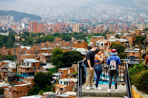 Medellin, Colombia - January 9, 2023: Tourists check their photos on a phone on a staircase in Comuna 13