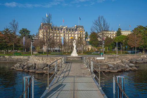 Lausanne, Switzerland - Dec 04, 2019: Place du Vieux-Port Fountain and Beau-Rivage Palace Hotel at Ouchy Promenade - Lausanne, Switzerland