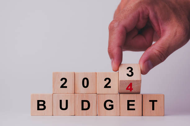 istock 2024 Budget planning and allocation concept. Hand flips wooden cube and changes the inscription 