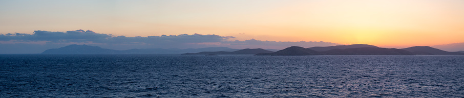 Rocky Island on Mediterranean Sea.  Rinia near Mikonos, Greece, Europe. Nature Background Panorama. Sunrise Sky