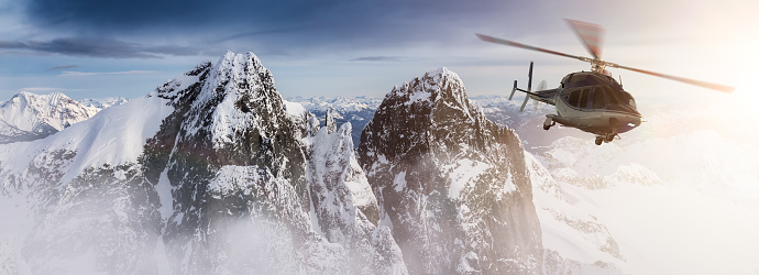 Helicopter flying over the Rocky Mountains during a colorful sunset. Aerial Landscape from BC, Canada near Squamish. Epic Adventure Composite. 3D Rendering Heli