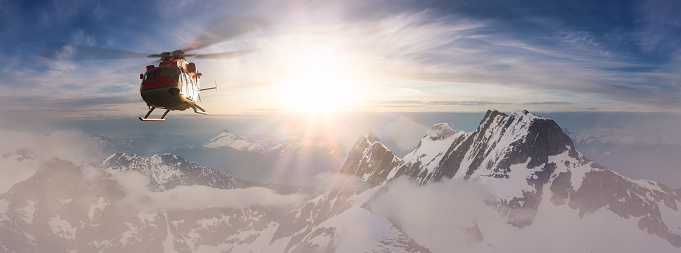 Helicopter flying over the Rocky Mountains during a colorful sunset. Aerial Landscape from BC, Canada near Vancouver. Epic Adventure Composite. 3D Rendering Heli